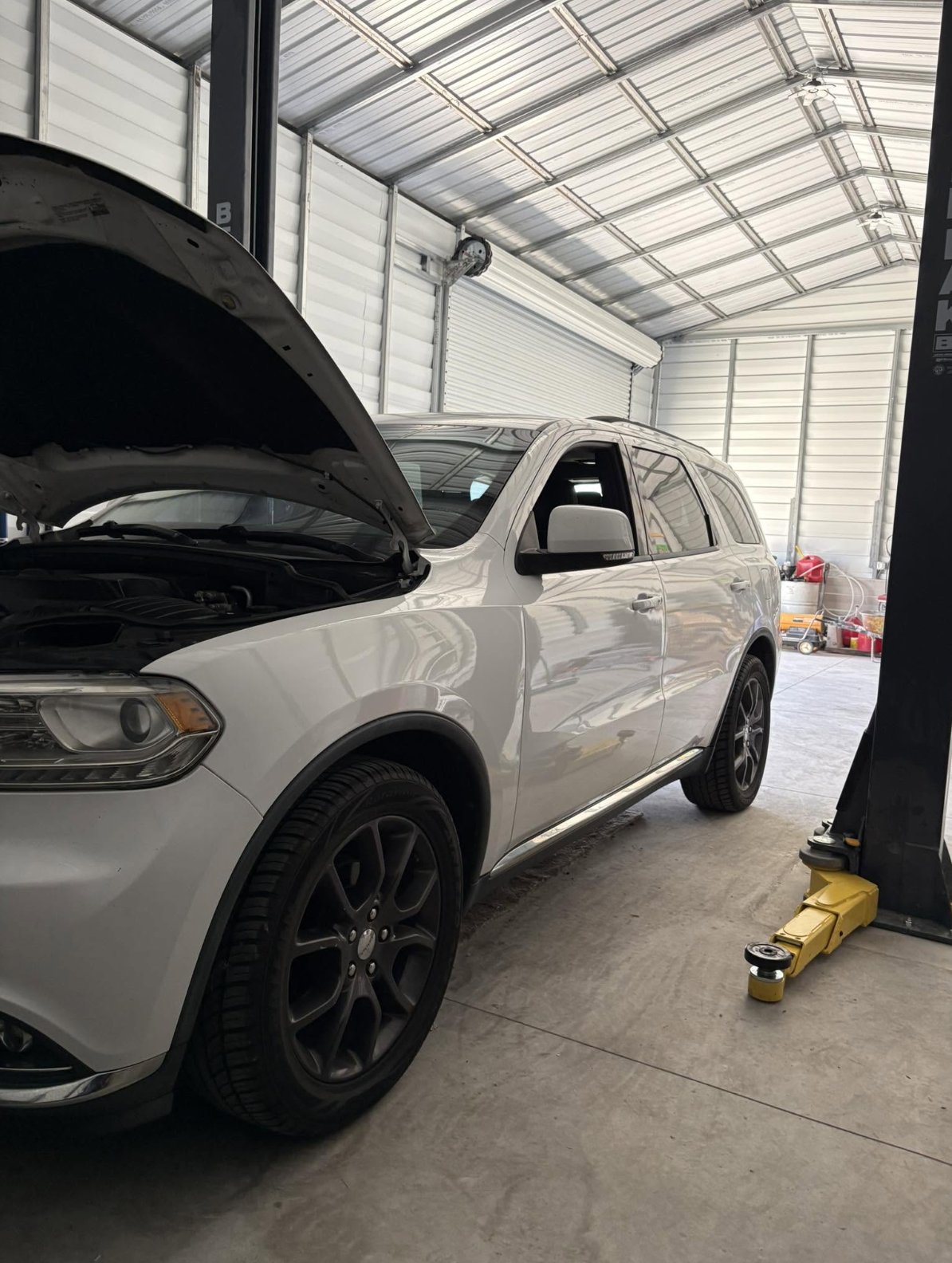 SUV with hood open inside the shop, ready for service